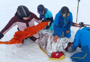 Eine Gruppe übt erste Hilfe im Schnee